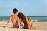 guy and his girlfriend sitting on the beach