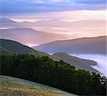 Pink autumn morning mountain view with sunbeam and haze