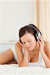 Close up of a Woman listening to music with closed eyes in the bedroom