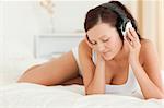 Woman listening to music with closed eyes in the bedroom