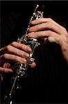 musician playing a clarinet isolated against black background