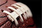 american football - macro over black with shallow depth of field and focus on first seam