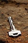 A bright key with shadow over the stone background. Shallow DOF