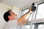 Man drilling a hole in a ceiling