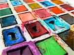 closeup of child's old tin toy paintbox with the brilliant colours of childhood; wide angle view; differential focus