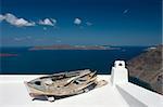 Old damaged  rowing boat placed on house roof