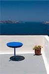 View from the balcony to Aegean Sea. Blue table and plant in vase standing on this balcony.