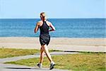 Young woman joggin by sea side in the summer