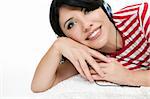 Casual dressed woman relaxing on cushion and listening to music.