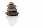 Stack of pebbles over white with reflection