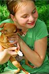 Smiling young girl holding a chihuahua puppy (who just licked her:))