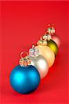 Some coloured Christmas balls on a red background. Focus at front