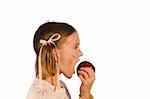 Very dirty young girl taking a bite from an apple. Studio shot isolated on a white background.
