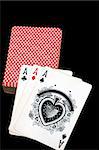 Three aces and a card deck on a black background