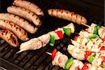 Sausages and chicken kebabs on a barbecue