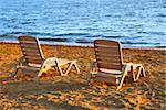 Beach chairs on sea shore in late afternoon