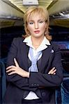 Blond air hostess (stewardess) in the empty ariliner cabin
