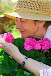 Portrait d'une femme senior heureux dans son jardin, odeur de fleurs