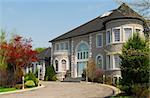 Front of a large beautiful executive home under blue sky