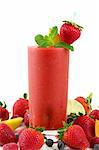 A glass of strawberry smoothie surrounded by fresh fruits