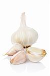 Garlic and cloves reflected on white background. Shallow DOF