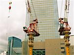 construction site with two cranes and modern high rise buildings background