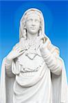 beatiful white statue of Virgin Mary on blue background