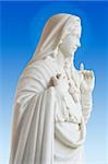 beatiful white statue of Virgin Mary on blue background