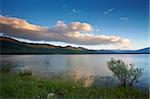 Cloudy sunset over the peaceful lake on spring