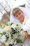 newlywed bride  shows us bouquet of flowers smiling