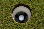 Image of a golf ball in the hole on green