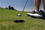 Close up image detail of a golfer lining up a putt on the green