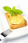 Fork and apple tart with leaves of mint on a dish. Soft shadow, isolated on white background