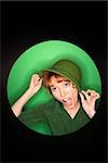 Vignette of Caucasian mid-adult woman tilting hat on green background.