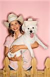 Caucasian prime adult female and white terrier dog wearing cowboy hats.