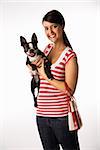 Young adult female Caucasian holding Boston Terrier dog.