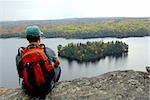 A hiker sitting on a cliff edge enjoying scenic view