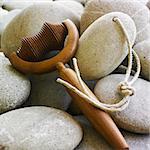 Hot white stones heaped in a pile and roller tool with wooden handle for use in hot massages