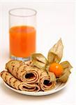 Pancakes on a plate and a glass with carrots juice