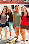 Portrait of a group of four young girls near school building