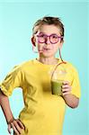 A boy sips a healthy juice containing wheat and barley grass through a crazy straw. Wheatgrass in juice has been proven over many years to benefit people in numerous ways: cleansing the lymph system, building blood,  removing toxic metals from the cells, nourishing the liver and kidneys and restoring vitality.