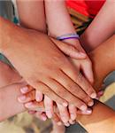 Hands of diverse group of teenagers joined in union