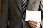 Smartly dressed business man holding a white card (enter your own text).