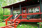 Woman sitting on a deck of log cabin