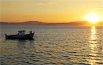 Image shows a fishing boat at sunset