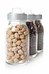 Glass jars of chickpeas, red beans and lentils, with soft shadow  reflected on white background. Shallow DOF