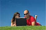 Beautiful couple of boyfriends having fun with a laptop