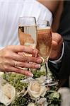 Glasses of champagne of champagne in a hand of the groom and bride