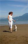 woman running with her dog on the beach