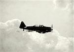 Black and white photo of vintage airplane in flight